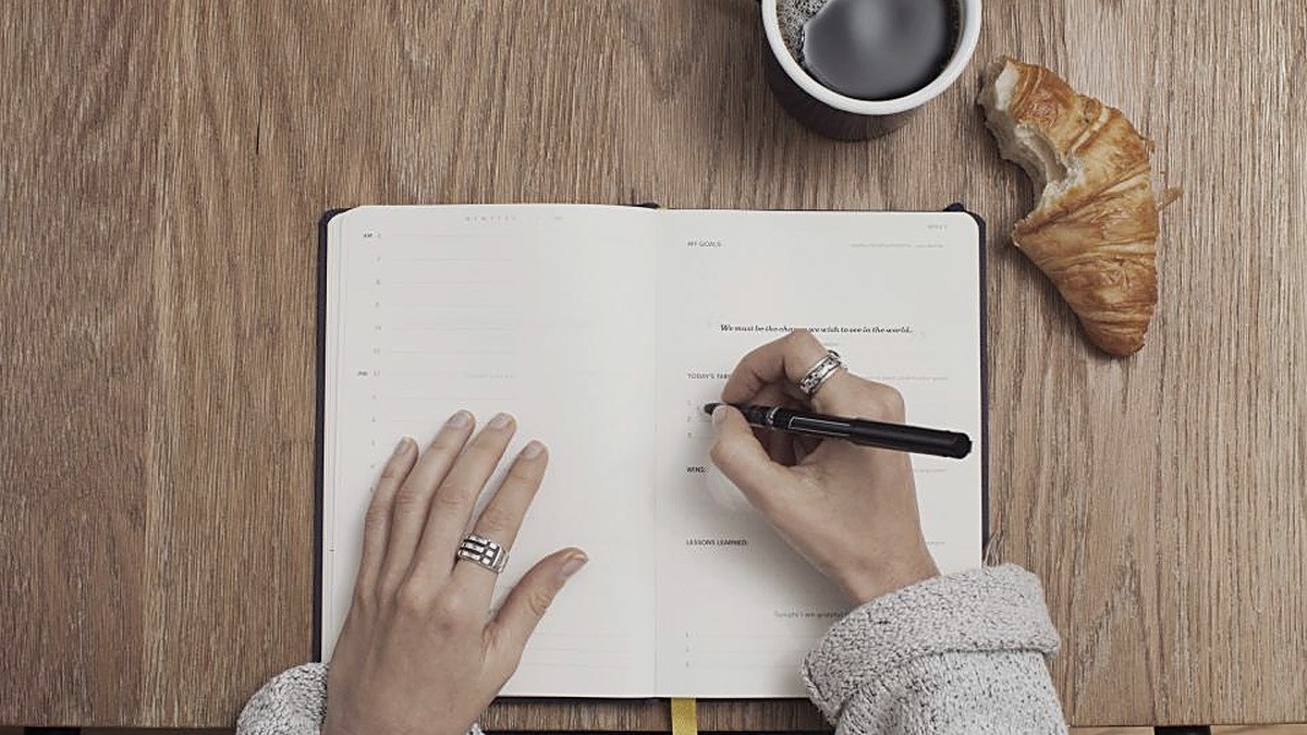 A photo of a hand writing something down in a notebook