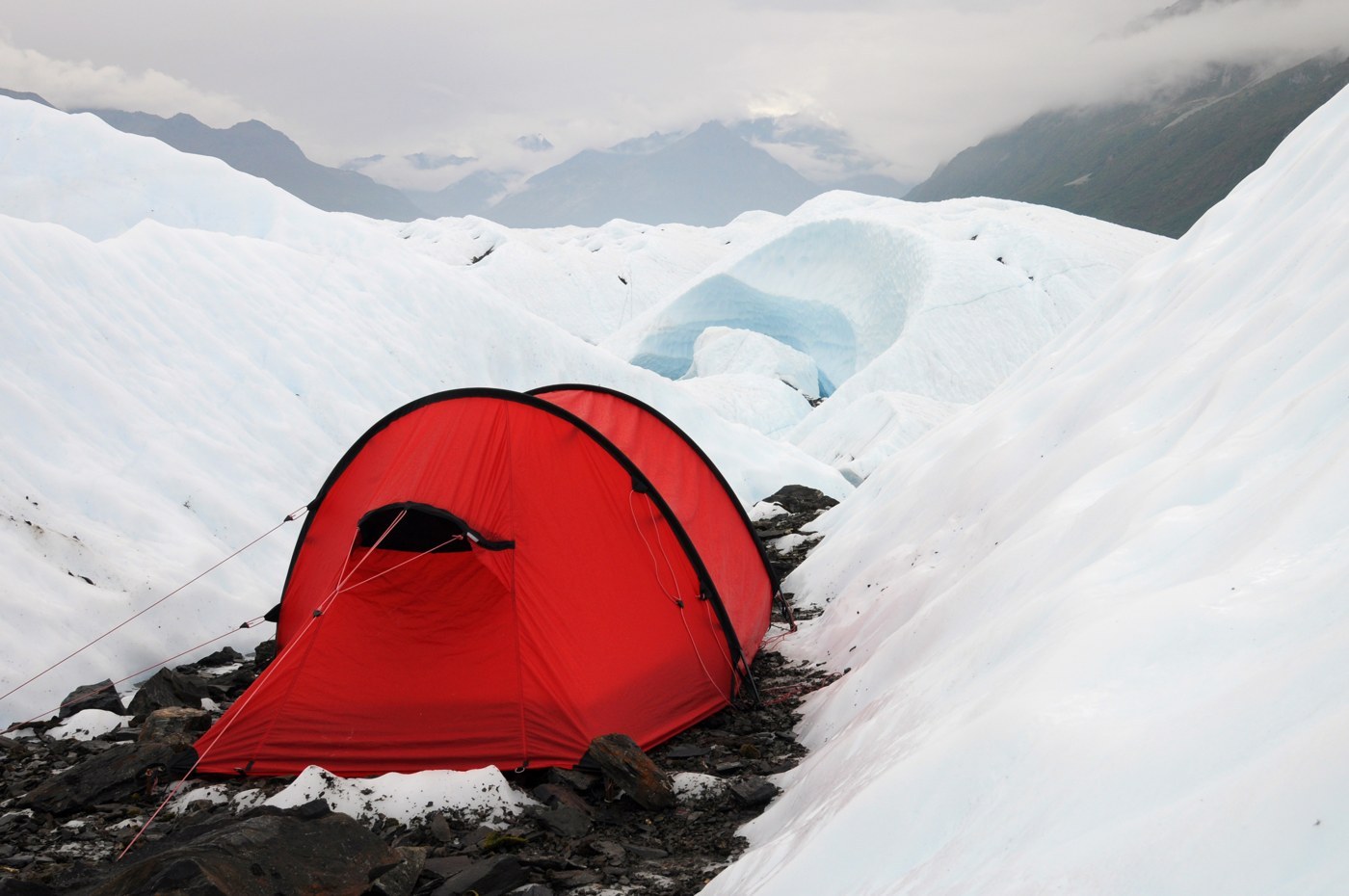 A green tunnel tent pitched on snow on a glacier. Two parallel arches hold it up, with guylines pulled taut front and back (photo Paxson Woelber, Wikimedia Commons, CC BY 2.0)